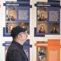 A man framed against a wall of stories from Contemporary Stories of Saugatuck